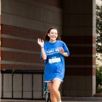 Individual waving to camera while running